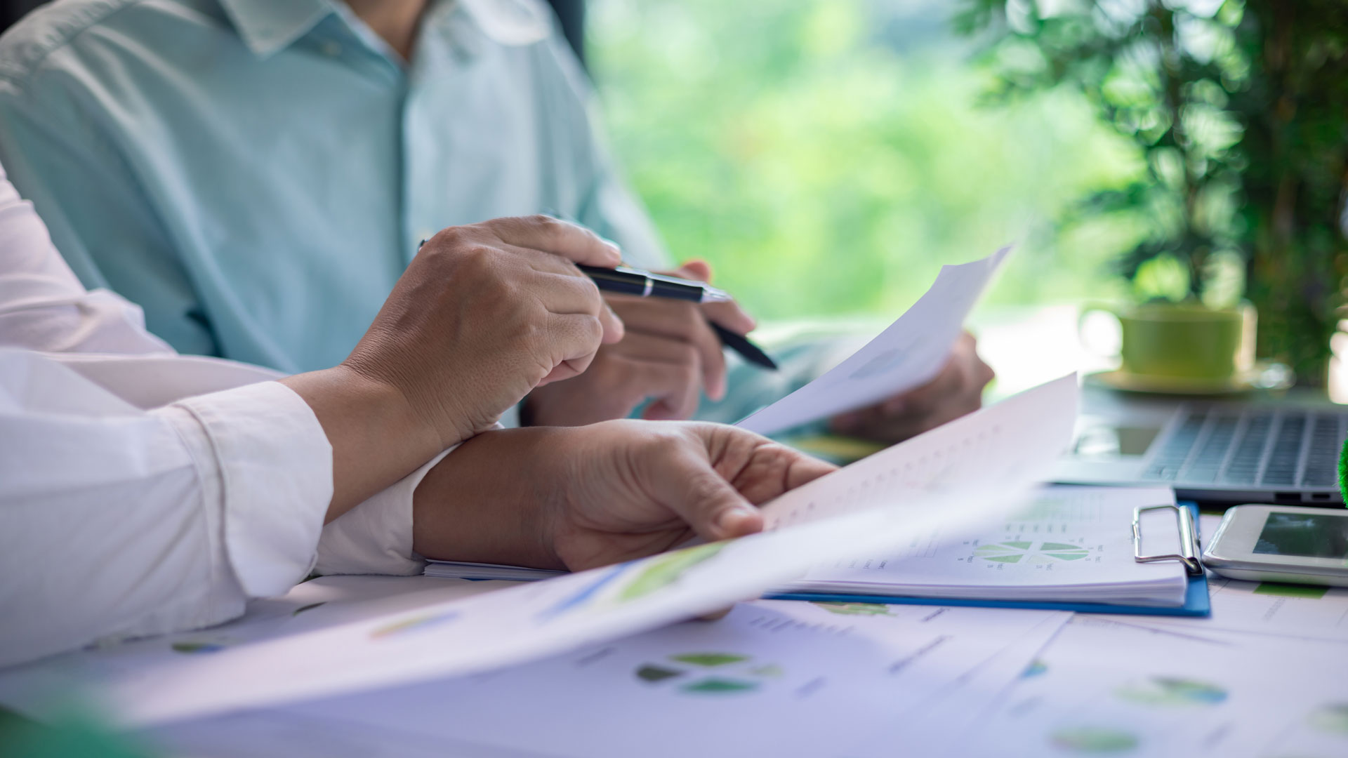 Rahanpesulaki säätelee myös isännöintiä. Kuvassa kaksi ihmistä selaa papereita.